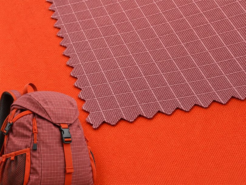 Polyester ripstop and functional fabric with durable grid construction for outdoor apparel and technical applications.