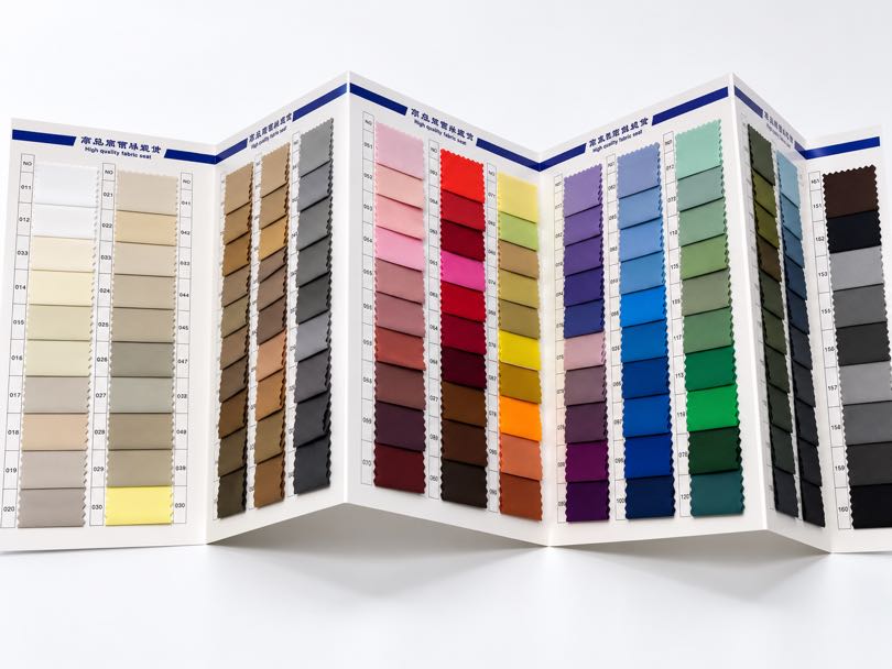 Polyester and nylon taffeta fabric swatches in multiple colors and specifications for apparel sourcing.